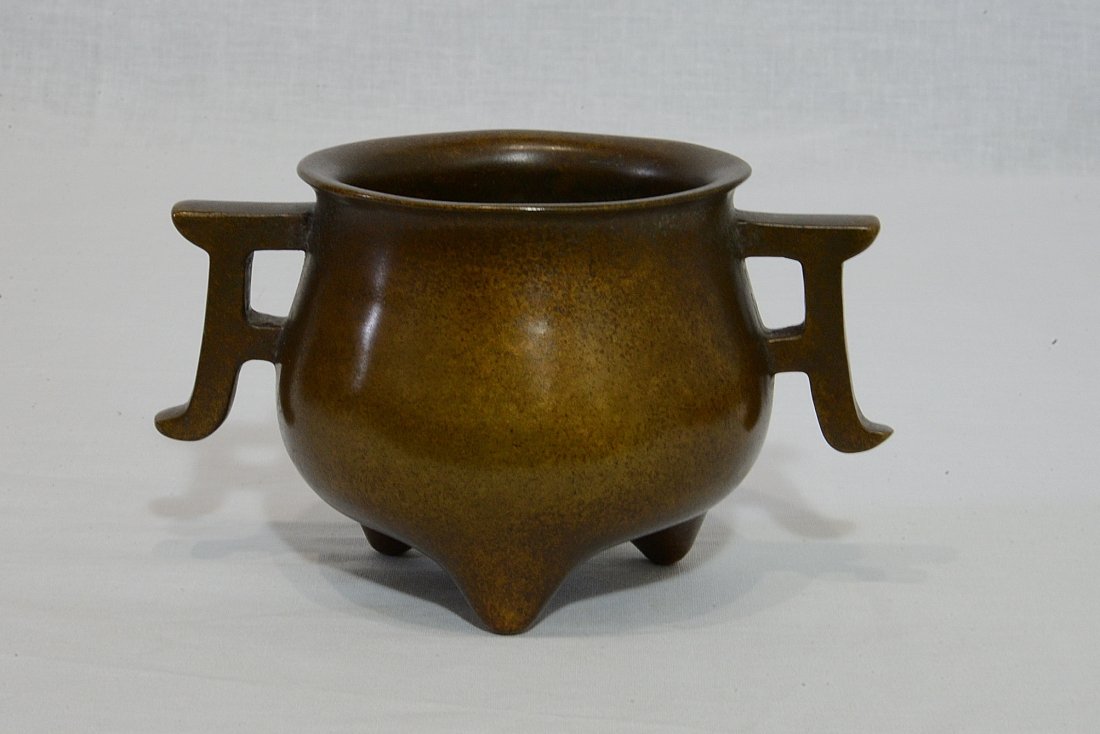 Chinese Bronze Tripod Incense Burner With Mark: Chinese bronze tripod incense burner with handles. Four character relief studio mark on the base. Good condition. 5.5" diam x 3.5" height.