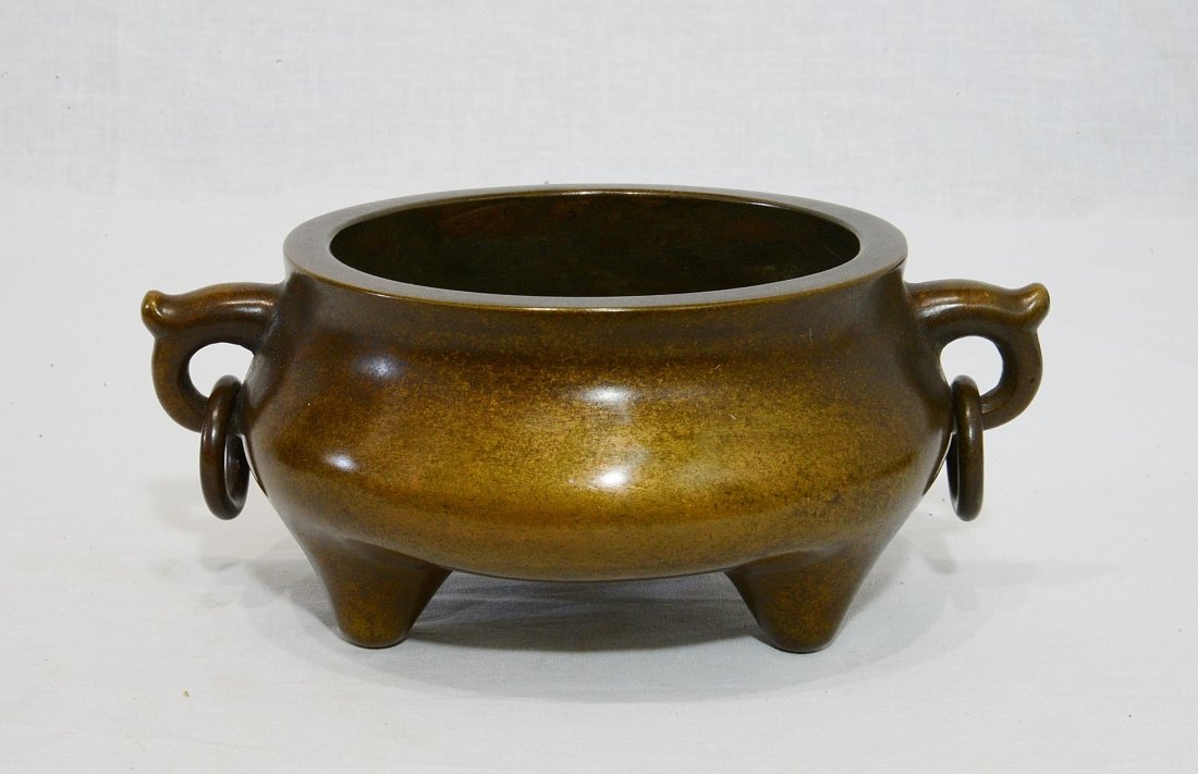 Chinese Bronze Tripod Incense Burner With Mark: Chinese bronze tripod incense burner with ring on the handles on the side. Four character relief mark on the base. Good condition. 8.5" diam x 3" height.