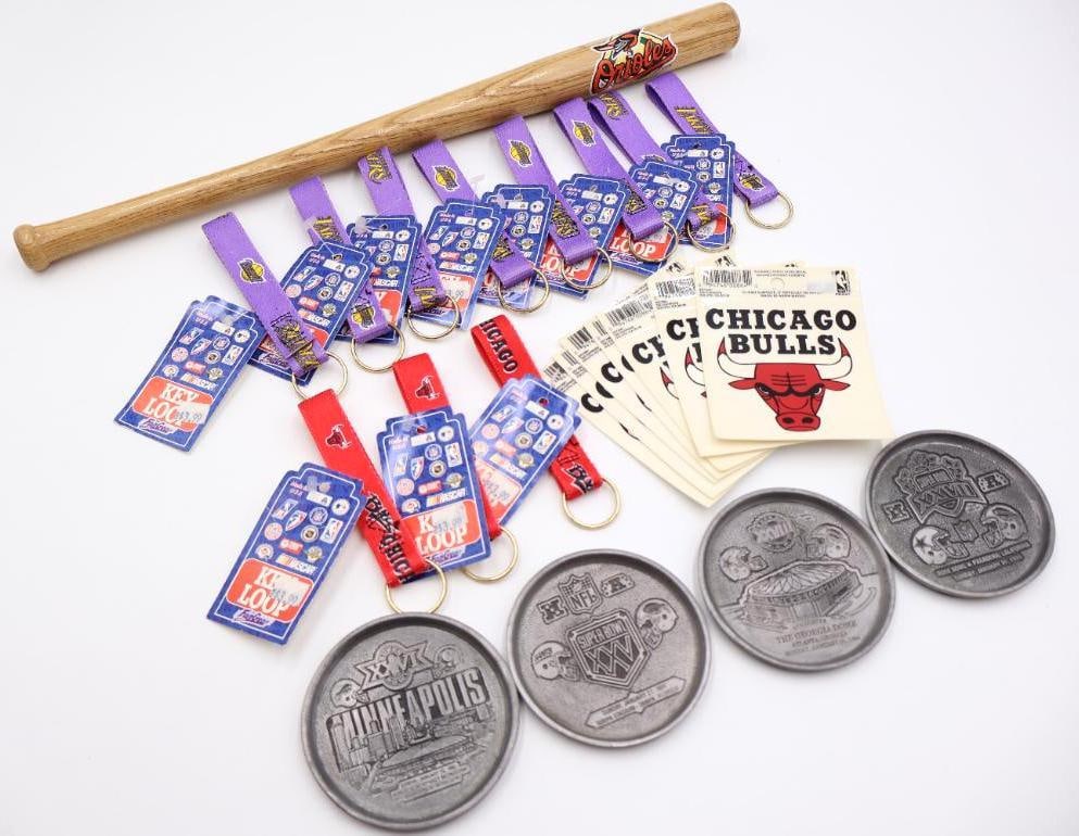 Assorted Sports Collectibles from NBA, NFL and MLB: Orioles small bat, Chicago Bulls stickers and keychains, Lakers keychains, and Superbowl metal coasters