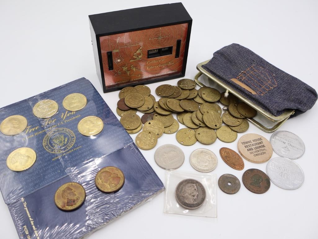 Coin Collection with Assorted Holders and Cases: Display folder containing several large commemorative coins, still wrapped in clear plastic, in the center, there is a pile of numerous round brass-colored tokens or coins, many with small holes near