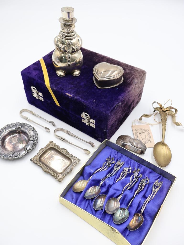 Vintage Silver Plated and Metal Collectible Set: A heart-shaped trinket box, silver plated snowman salt shaker, gold-toned spoon tied with a ribbon and accompanied by a small tag, a small ornate rectangular tray with decorative edges, velvet box wit