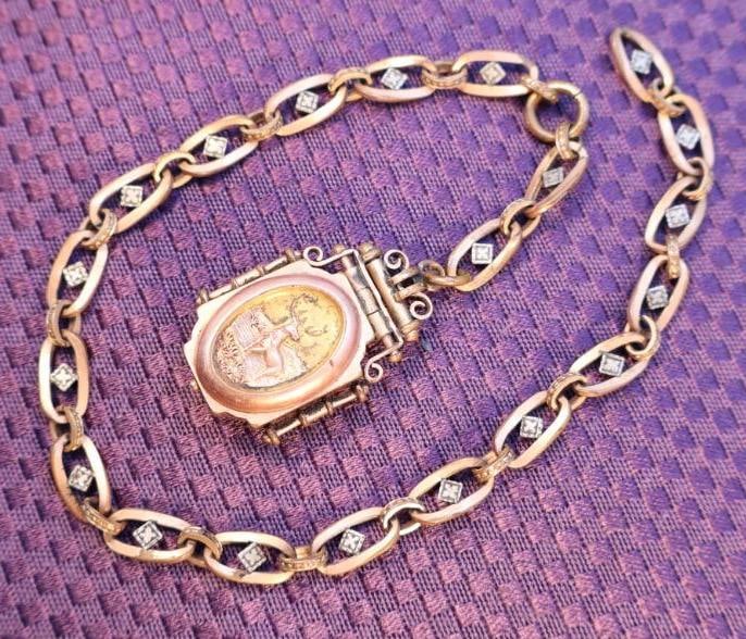 Antique Victorian gold-filled locket and chain featuring a deer motif: Antique gold locket watch chain. Likely from the Victorian era (18371901) and features a central locket with a deer motif, possibly set with small diamonds or diamond accents on the chain links. The p