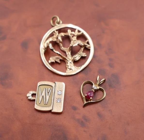 14k and 10k yellow gold pendants: 10k yellow gold computer wiz charm pendant featuring two diamonds, a 14k round Tree of Life pendant, and a 1ok heart-shaped pendant set with a ruby and diamonds. Click on the main photo to view