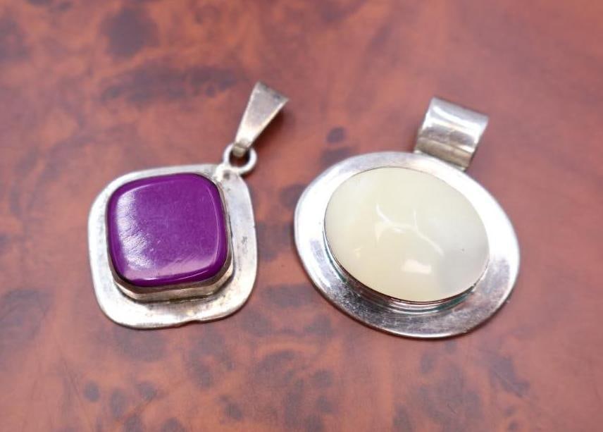 Two vintage sterling silver pendants: One featuring a purple square stone (possibly chalcedony or sugilite) and the other an oval pale yellow/white stone (possibly lavender jade or chalcedony). 