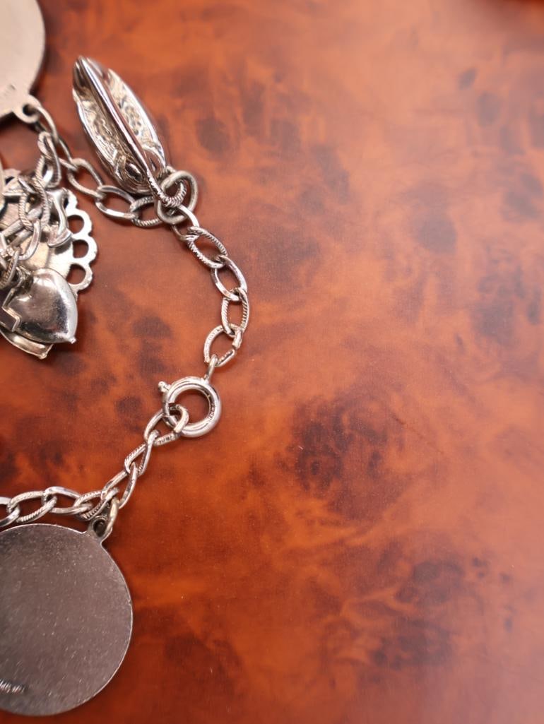 Vintage sterling silver charm bracelet with assorted collectible charms - 12