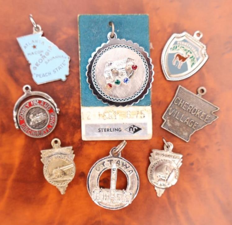 Collection of vintage sterling silver travel charms: The charms represent various locations including Macon, Georgia; Coney Island; Cherokee Village, Pennsylvania; and Ottawa. 
