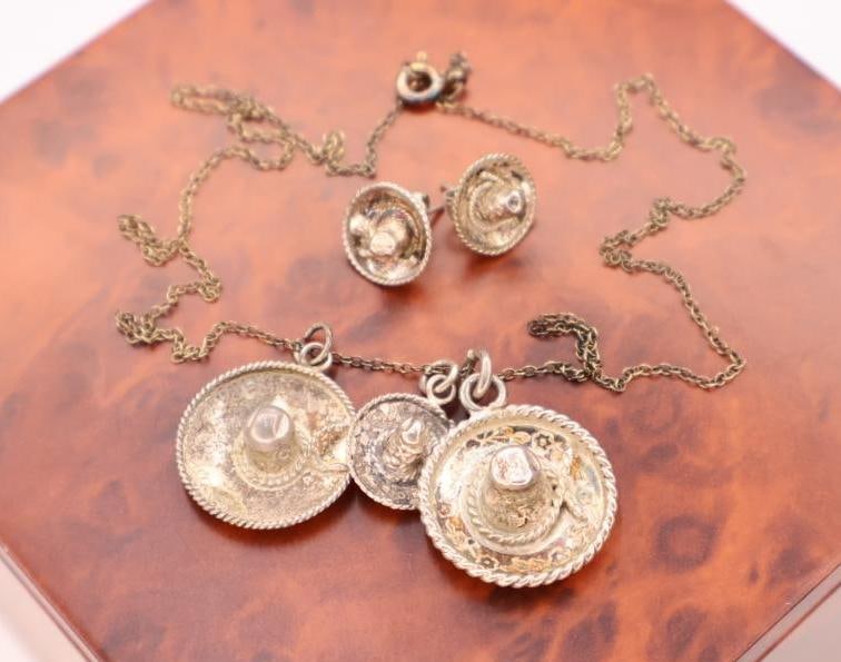 Vintage sterling silver jewelry set: This is a vintage sterling silver jewelry set featuring a necklace with sombrero hat pendants and matching earrings. 