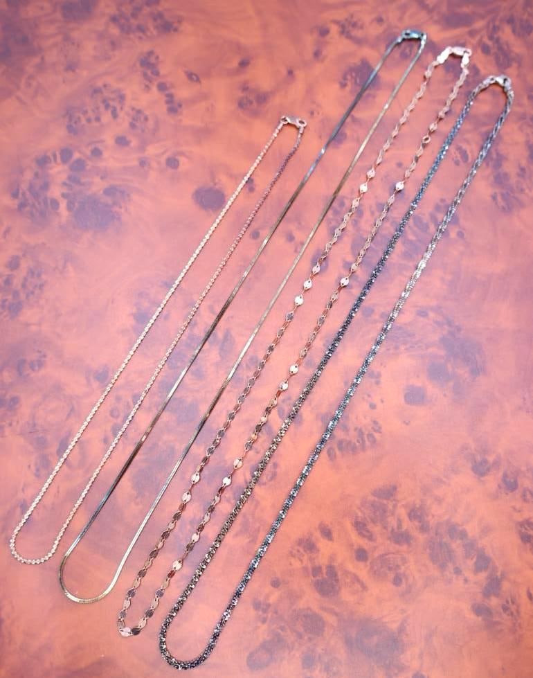 Assortment of chain necklaces wither different tones (1 of 12)