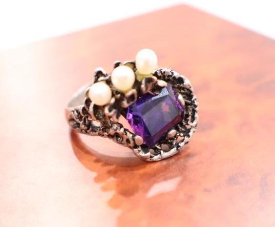 Marked 14k Amethyst and Pearl Ring: Adorned with three pearls atop purple amethyst stone, ornate ring marked 14k on band. Size is approx. 7, total weight 8.11 grams including pearls and gem. 