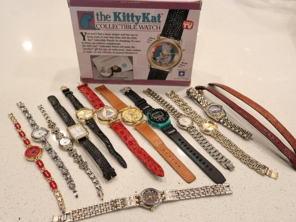 An eclectic collection of 12 assorted wristwatches: Includes, The Kitty Kat Collectible Watch: This primary piece is a TV-advertised novelty watch featuring a charming kitten graphic on the dial. It is presented in its original purple and white box,