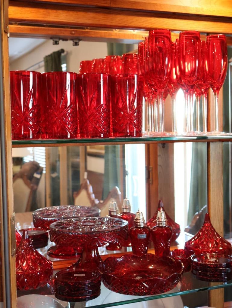 Collection of Royal Ruby red glassware: All made by Dublin Collection. set of heavy-based tumblers with a geometric "star" or "diamond" cut pattern and a group of elegant champagne flutes with clear glass stems. A substantial array of servi