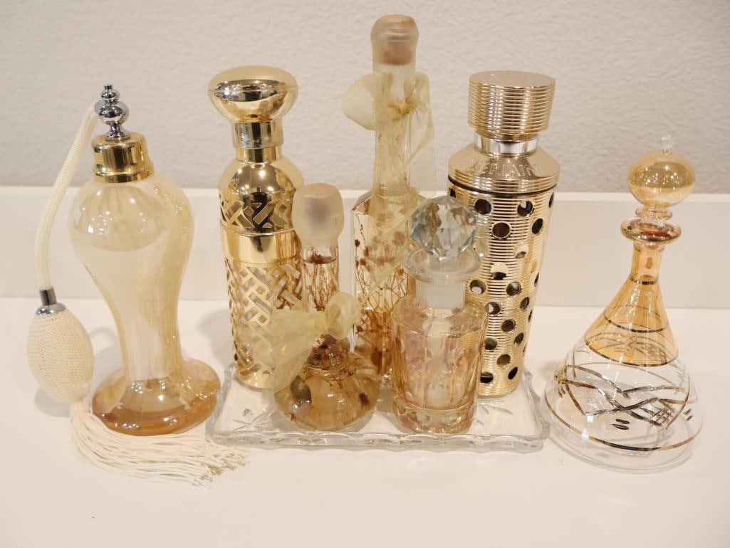 Exquisite collection of vintage perfume bottles and atomizers: These pieces are highly collectible for their intricate design. The collection includes multiple versions of the iconic Guerlain refillable atomizer cases. 