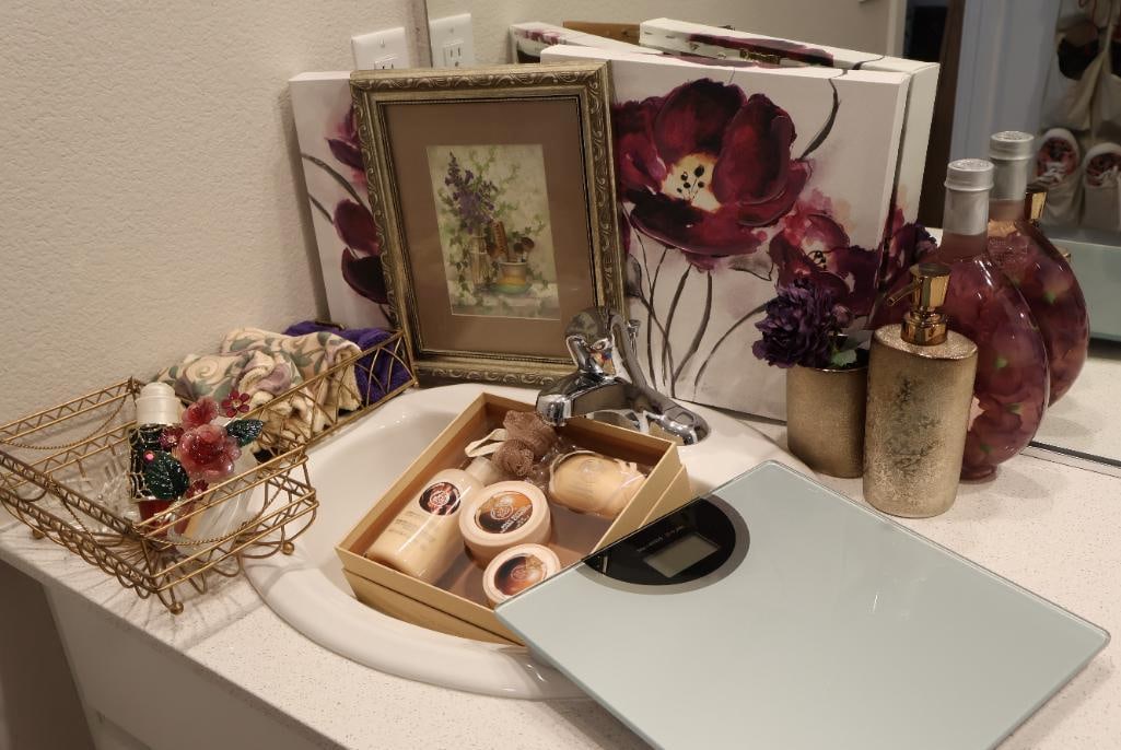 Bathroom Essentials Including Bathroom Decor Set: A bathroom scale, three pieces of art, soap kit and dispenser, a few hand towels, and metal storage. 