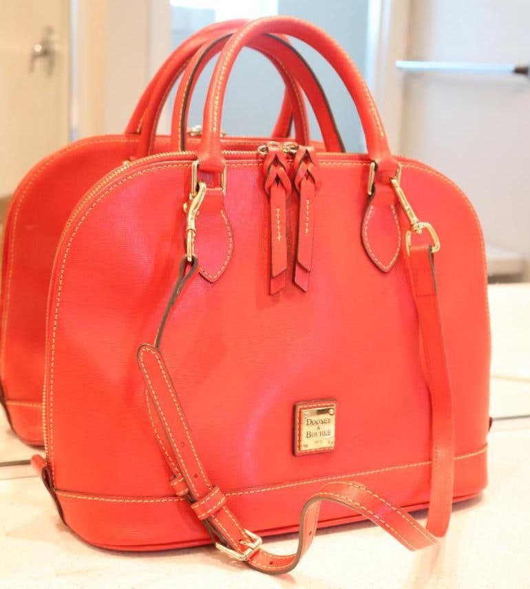 Red Dooney & Bourke Zip Zip Satchel: Signature all-around double zipper closure for security and easy access. Dual top handles with a 4" drop and an adjustable strap with a 15.5" to 23" drop. Protective metal feet on the bottom.