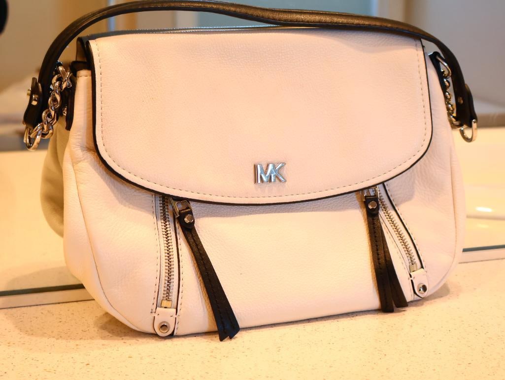 White Michael Kors Evie Medium Pebbled Leather Shoulder Bag: The Evie bag is a versatile accessory designed for everyday organization. A hobo-style shoulder bag with a curved flap and dual front zipper pockets with leather pull tabs. Very good condition. 