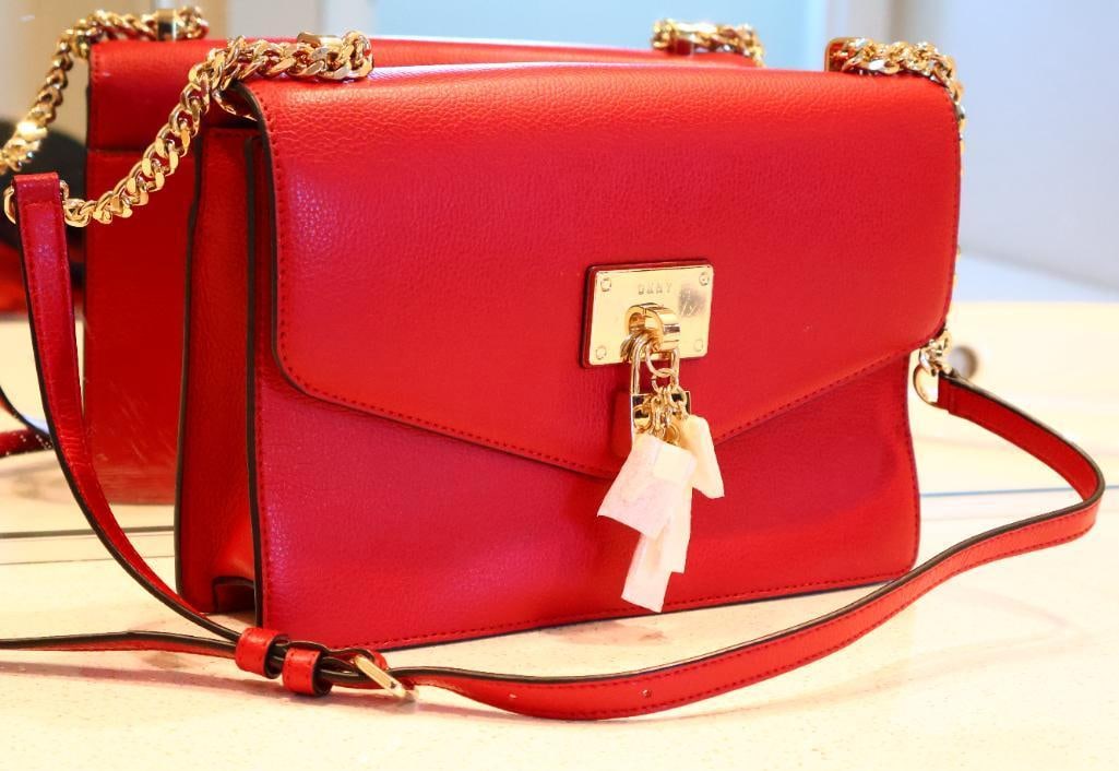 DKNY Red Elissa Leather Shoulder Bag: It is a signature piece from the DKNY collection, known for its structured yet elegant design. Like new with foam covering charms. 