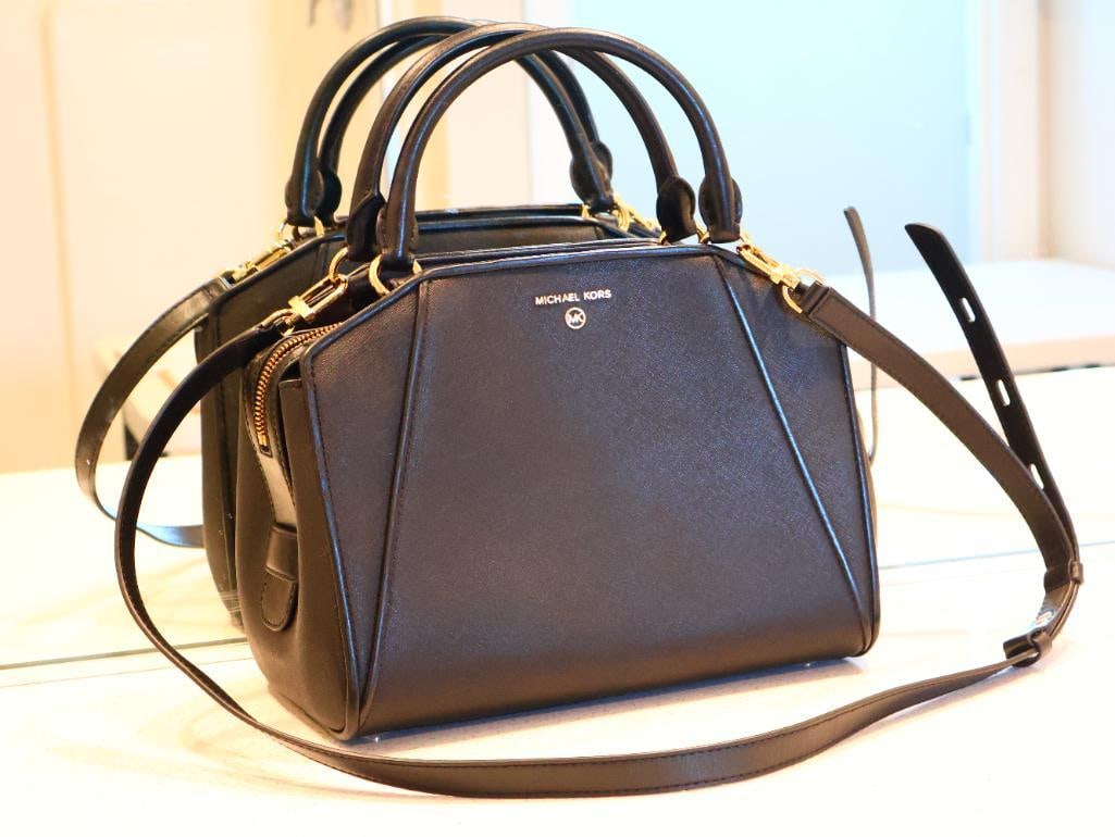 Black Michael Kors Cleo Medium Saffiano Leather Satchel: The Cleo satchel is designed as a structured handbag that balances elegance with practicality. Crafted from durable Saffiano leather, known for its crosshatch texture and resistance to scratches.