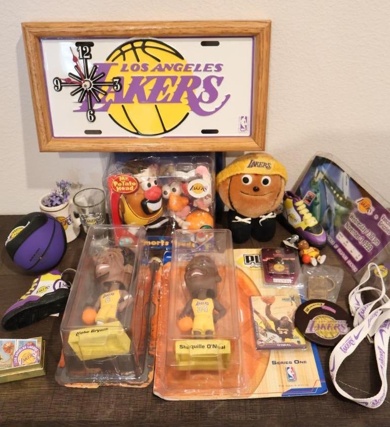 Collection of Los Angeles Lakers memorabilia: Features several iconic items from the 1990s and early 2000s, including NBA Sports Spuds Mr. Potato Head, Mattel Superstars Shooting Sensations, Upper Deck Playmakers Series One. 