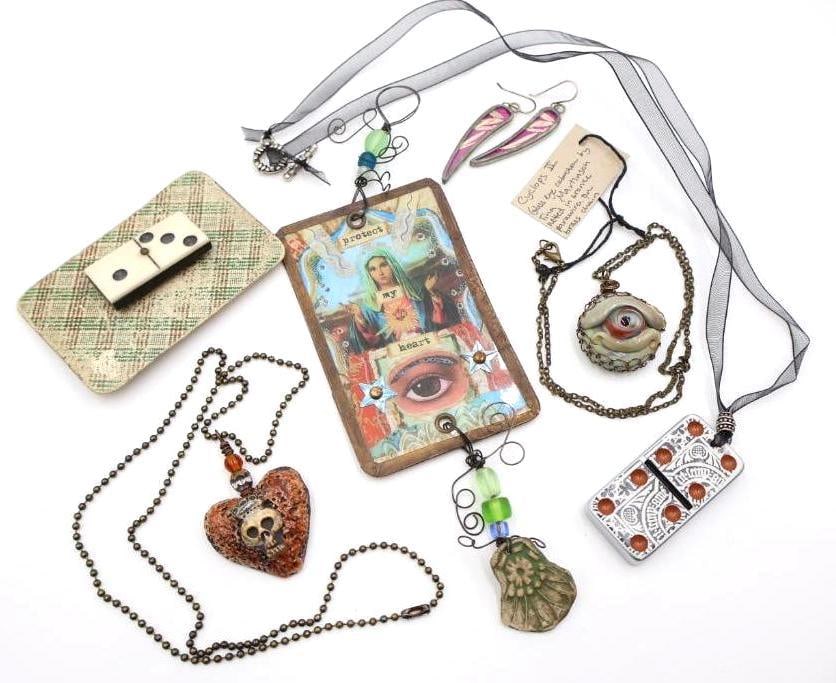 Assorted Handmade Jewelry and Trinkets: Handmade Artisan clay heart skull necklace, vintage domino and playing card pin, Madonna Protect my Heart 'strange and wonderful thing' by Clarissa Callesen signed on back, and glass eye 'Cyclops II' 