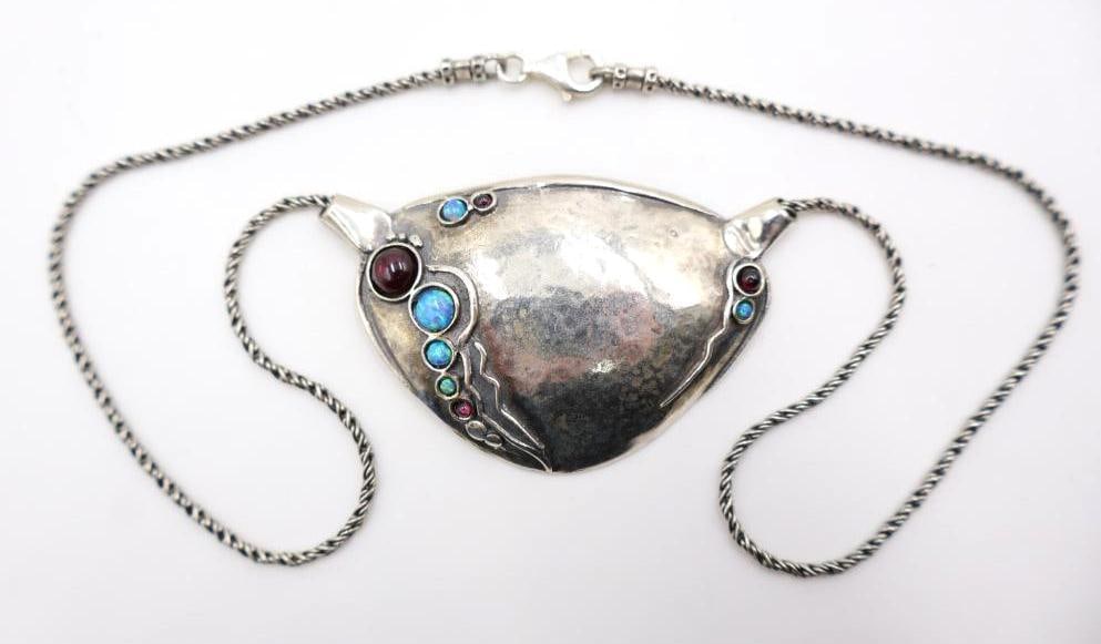 Sterling Silver Bib Shield Necklace: Lovely sterling silver marked with artists mark bib/shield style necklace adorned with garnet and blue opal-like gems