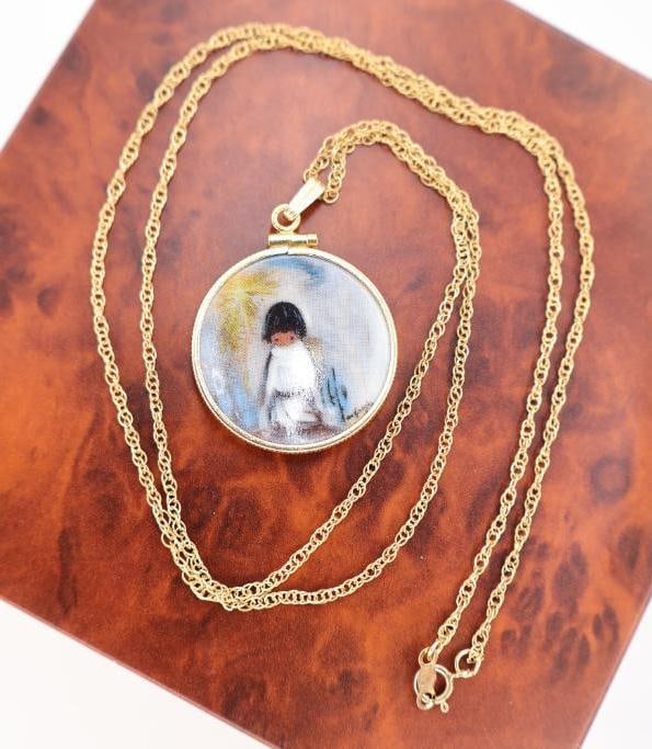 Vintage DeGrazia Style Portrait Pendant Necklace: Vintage gold-tone pendant necklace featuring a circular portrait medallion depicting a child in the distinctive Southwestern style popularized by renowned Arizona artist Ettore "Ted" DeGrazia. The