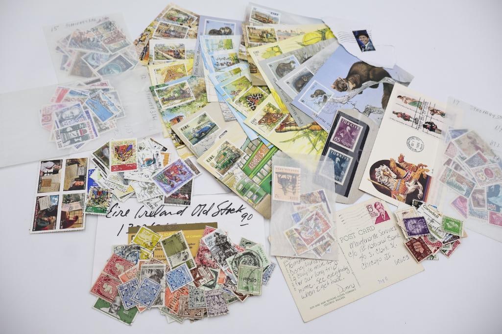 Large Worldwide Vintage Postage Stamp Collection: Large assortment of vintage worldwide postage stamps, stamp sheets, first day covers, postcards, and loose international stamps including Ireland, Turkey, and more. Includes colorful illustrated