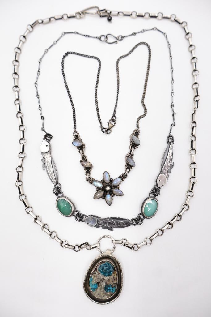 Collection of three sterling silver statement necklaces: Three distinct hand-crafted necklaces including (1) a delicate chain with a six-petal flower pendant and accents set with iridescent moonstone cabochons, (2) an organic-themed link necklace showcasing