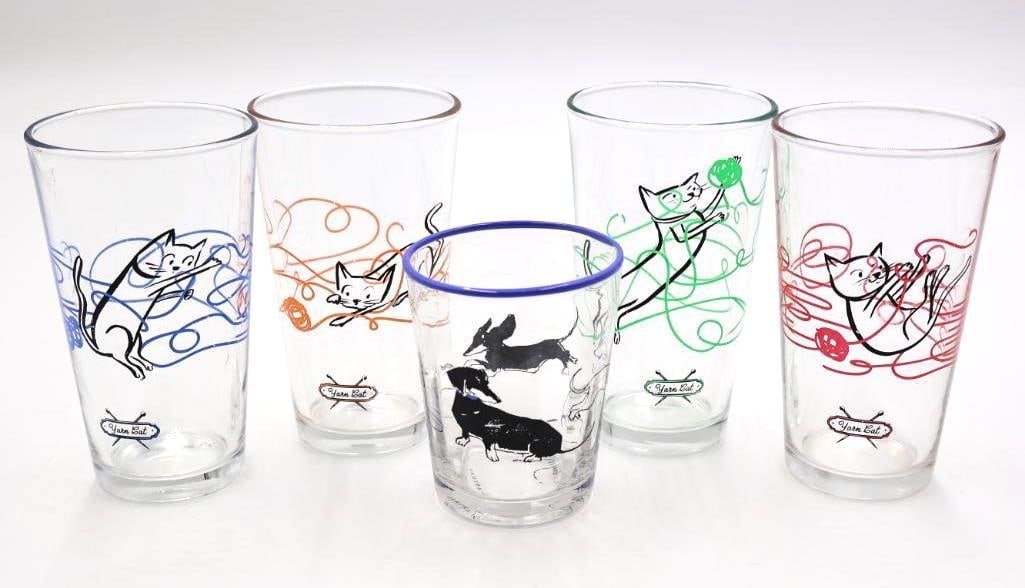 Set of 'Yarn Cat' Glasses and 'Do-a-Day' Glass: Anthropologie Sally Muir "Dog-a-Day" juice glass featuring a whimsical black dachshund illustration and a blue rim, and set of four Japanese Yarn Cat glasses