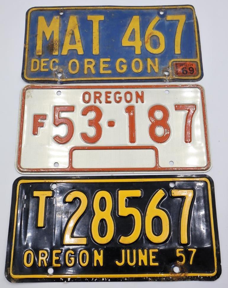 Three Vintage Oregon License Plates: 70's Oregon Farm plate, Oregon '57 Truck plate (looks to be painted black looking at the over spray on back), and blue and yellow Oregon plate with '69 sticker