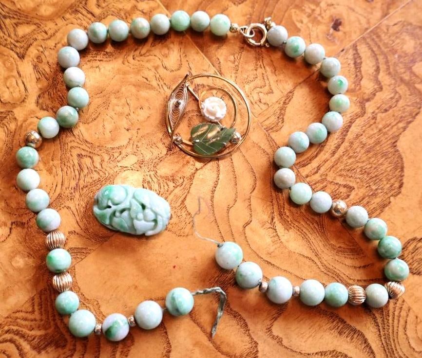 Jade Bead Jewelry Lot with 14K Gold Clasp and Carved Jade: Asian-inspired jewelry group featuring a broken green jade bead necklace with clasp marked 14K, carved green jade bead/pendant, and gold-tone floral brooch with carved white rose and green stone leaf.