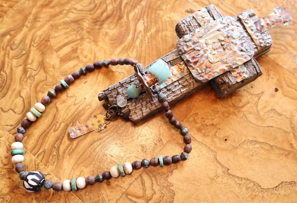 Southwestern Mixed Media Wall Sculpture and beaded Necklace: Two piece artisan collection including a rustic mixed-media wall sculpture constructed from weathered wood with hammered copper-tone metal, turquoise-colored stone and suspended bead accents.