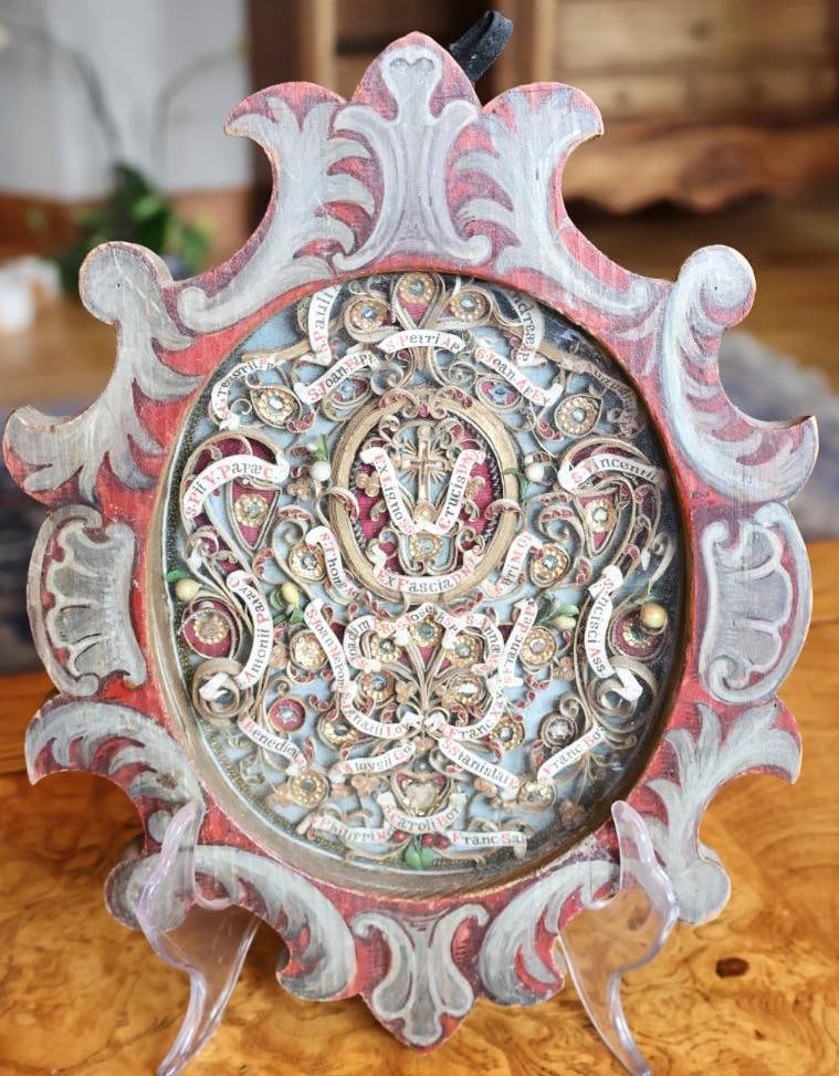Antique Venetian Multi-Saint Reliquary, Provenance Inscription Dated 1912: Ornate Catholic multi-saint reliquary featuring numerous labeled relic compartments arranged in gilt filigree with a central cross, colored textiles, beads and decorative elements, housed under glass