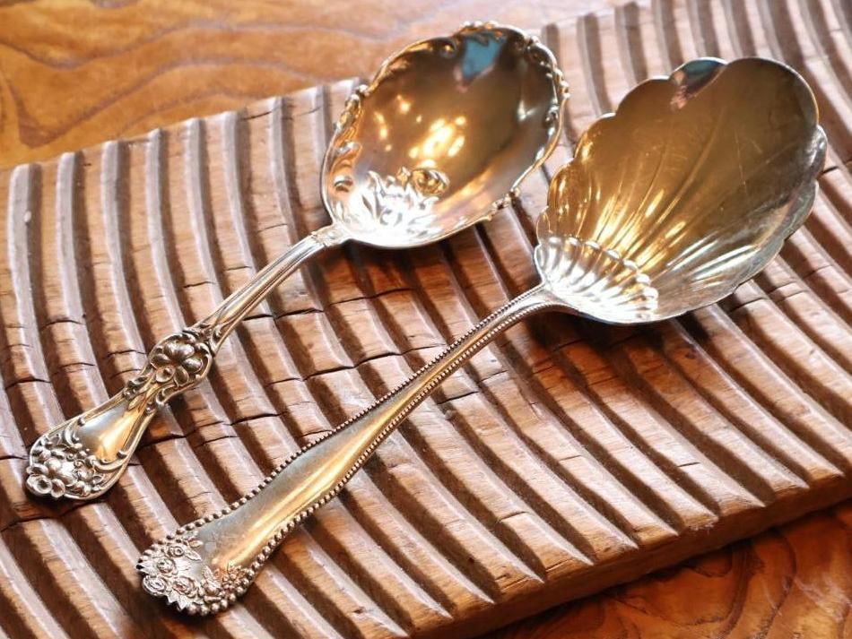 2 Antique Sterling Silver Ornate Serving Spoons Floral & Shell Patterns: Two antique/vintage sterling silver serving spoons in ornate patterns. Includes a large shell-form spoon with beaded border and floral handle decoration, and a floral-decorated serving spoon with