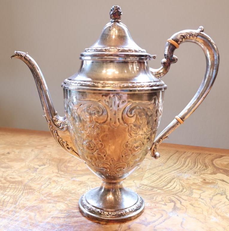 Frank M. Whiting and Co. Hand-Chased Sterling Silver Coffee Pot: Frank M. Whiting and Co. sterling silver covered coffee pot featuring elaborate hand-chased floral and scroll decoration, pedestal base, domed hinged lid with decorative finial, elongated curved