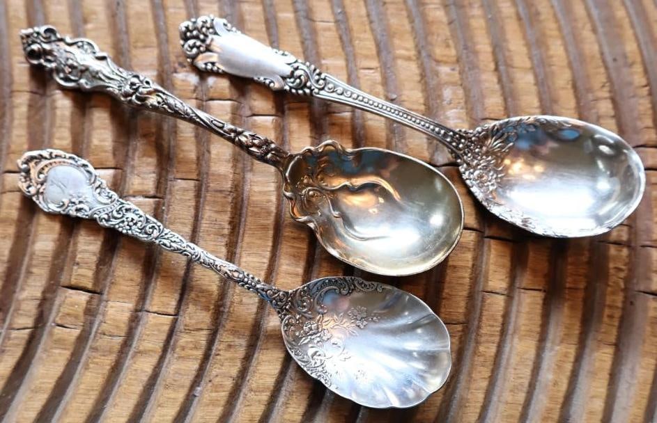 Lot of 3 Ornate Sterling Silver Serving Spoons, 94g: Group of three assorted sterling silver serving spoons featuring ornate floral, scroll and figural decoration. Each marked Sterling, with additional maker/pattern markings and monograms as shown.
