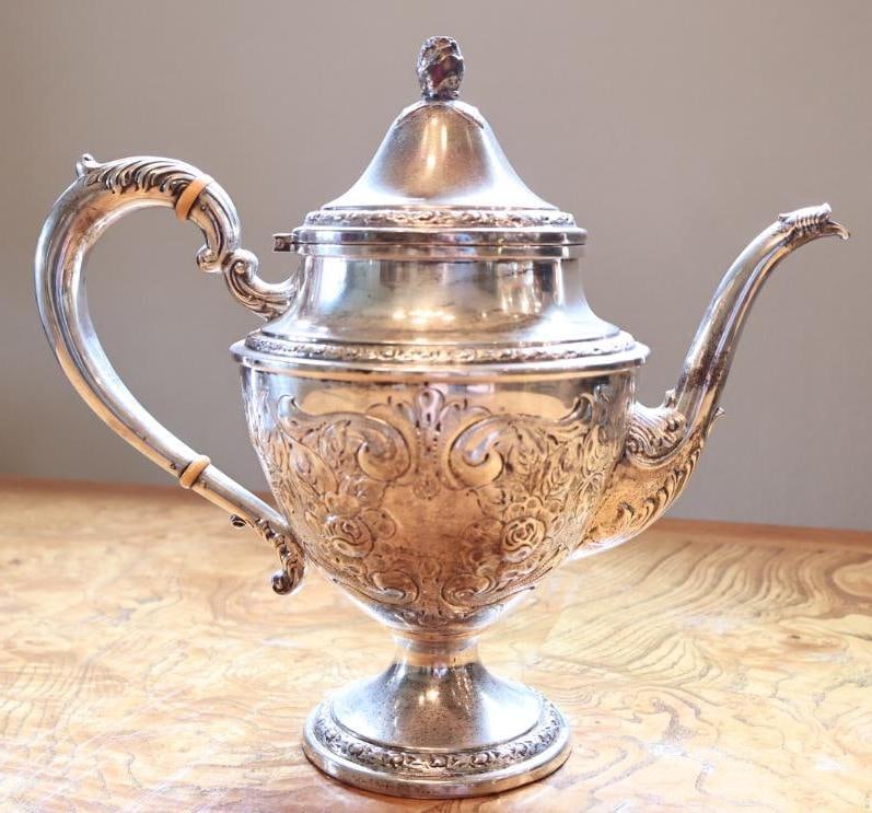 Frank M. Whiting & Co. Hand-Chased Sterling Silver Teapot: Frank M. Whiting and Co. sterling silver teapot featuring ornate hand-chased floral and scroll decoration, pedestal base, domed hinged lid with decorative finial, curved spout, and scrolling handle
