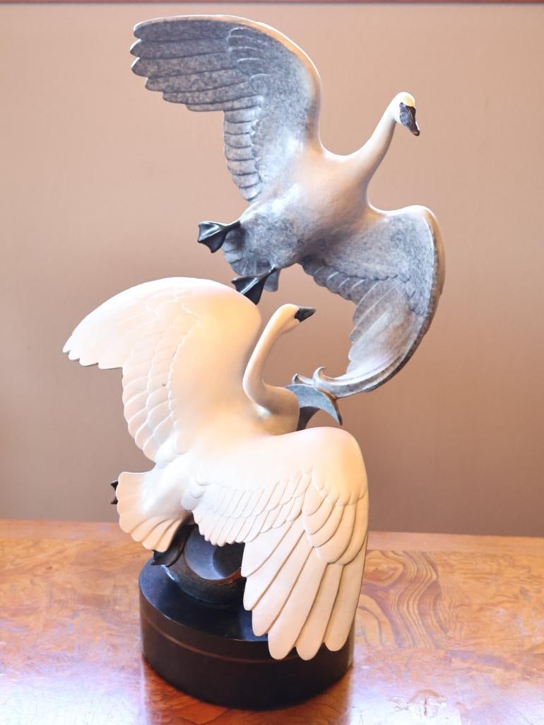 Large Limited Edition 'Wild Wings' Swan Bronze by Jacques and Mary Regat, 67/75, 1994: Limited Edition: 67/75 Dated: 1994, Rotating Base, includes Certificate of Authenticity that states ' Two Trumpeter Swans flying over a free form wave. Bronze statue on a black stone and white marble