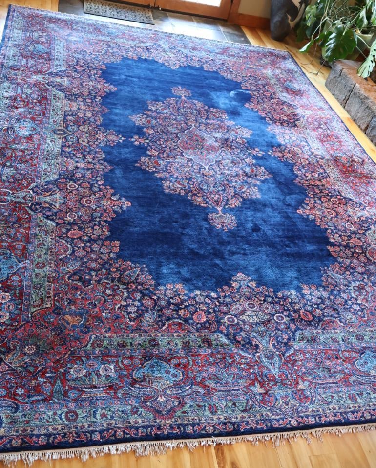 Large Persian-Style Floral Medallion Rug with Woven Inscription: Large Persian-style area rug featuring an elaborate central medallion and dense floral design in deep blue, red, ivory, green, and muted rose tones. Woven signature/inscription incorporated into the f