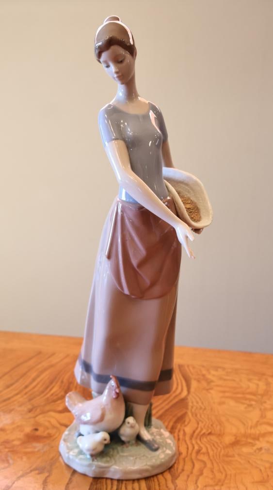 Lladro Feeding the Chickens Woman with Hen & Chicks Porcelain Figurine: Marked Lladro, Hand Made in Spain on underside and impressed 6970. Measures approximately 10" H.
