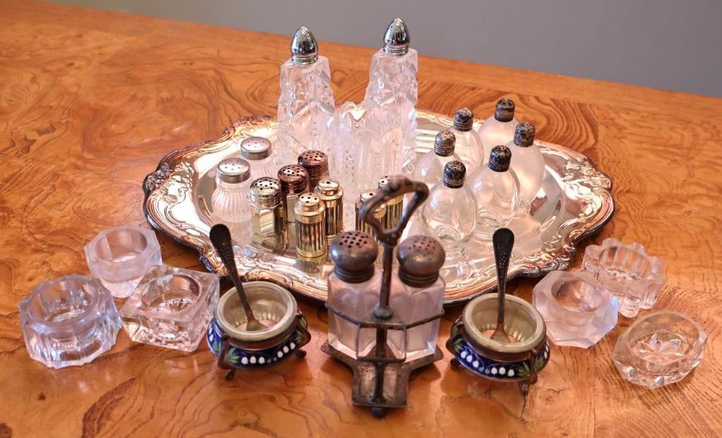 Vintage Sterling Silver-Topped Glass Shakers, Crystal Condiment Pieces and Enamel Salt Cellars: Six of the shaker lids are marked STERLING. Lot also includes additional shakers with various silver-tone and gold-tone tops and an ornate silverplate serving tray.