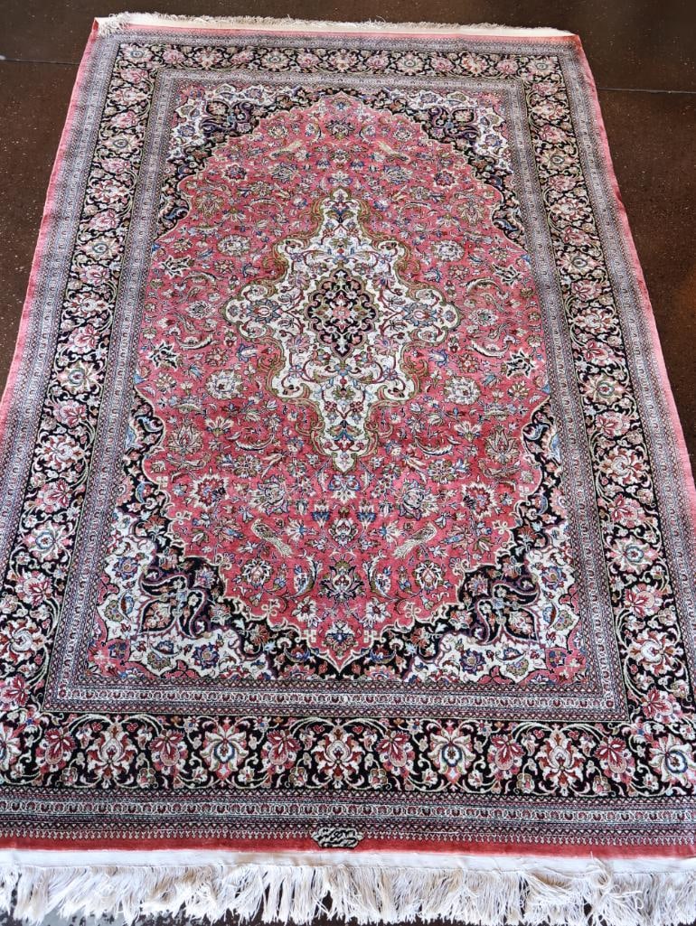 Exquisite Vintage Silk Qum Rug: 4'8" by 7', this beautiful fringed silk hand knotted rug has the original tag stating $3,750. Qum rugs are universally celebrated as some of the finest, most luxurious hand-knotted textiles in the