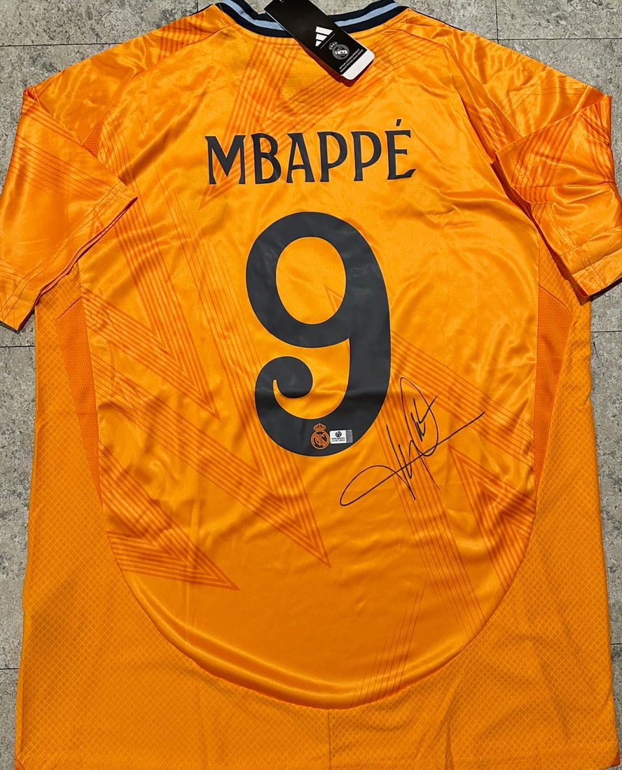 Kylian Mbappé Real Madrid Autographed 2024-25 Adidas Away Orange Jersey coa: Kylian Mbappé Real Madrid Autographed 2024-25 Adidas Away Orange Jersey GA coa - Autograph Location & coa # may vary JERSEY SIZE EXTRA LARGE 