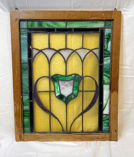 4 Antique Stained Glass Window Panels: This lot includes four stained glass window panels featuring a charming Art Nouveau-style motif with arched elements, flowing heart-shaped curves, and a central shield medallion. The design incorporat