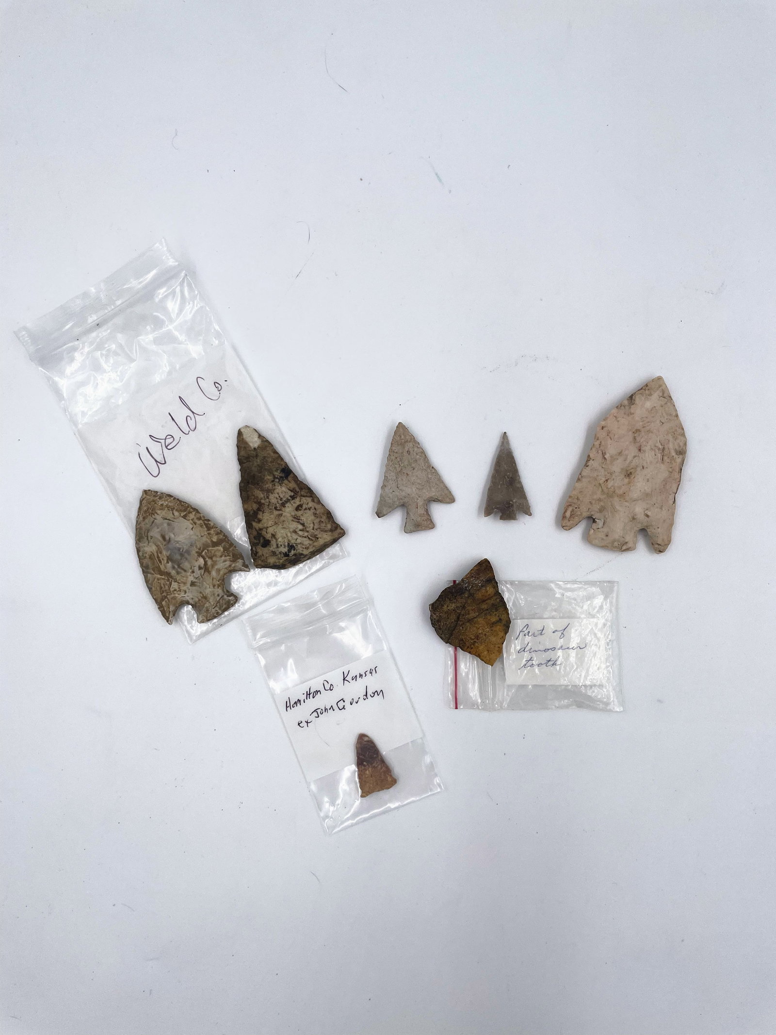 Group of Midwestern Arrowheads: A mixed lot of stone points and fragments, including labeled examples from Weld County, CO and Hamilton County, KS. Varied in size and form, this grouping includes notched, stemmed, and triangular typ