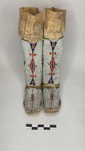 Beaded Hightop Mocs - Plains - pre 1900: Tall hightop moccasins with extensive white field beading, decorated with symmetrical red and blue motifs up the shaft.reference: native american, indian artifact, arrowhead, paleo, clovis, dalton, be
