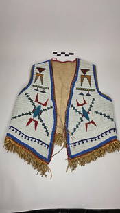 Sioux Beaded Vest - pre 1900: Heavily beaded hide vest with human figures and geometric motifs on a white background. Finished with fringe trim and colorful border.reference: native american, indian artifact, arrowhead, paleo, clo