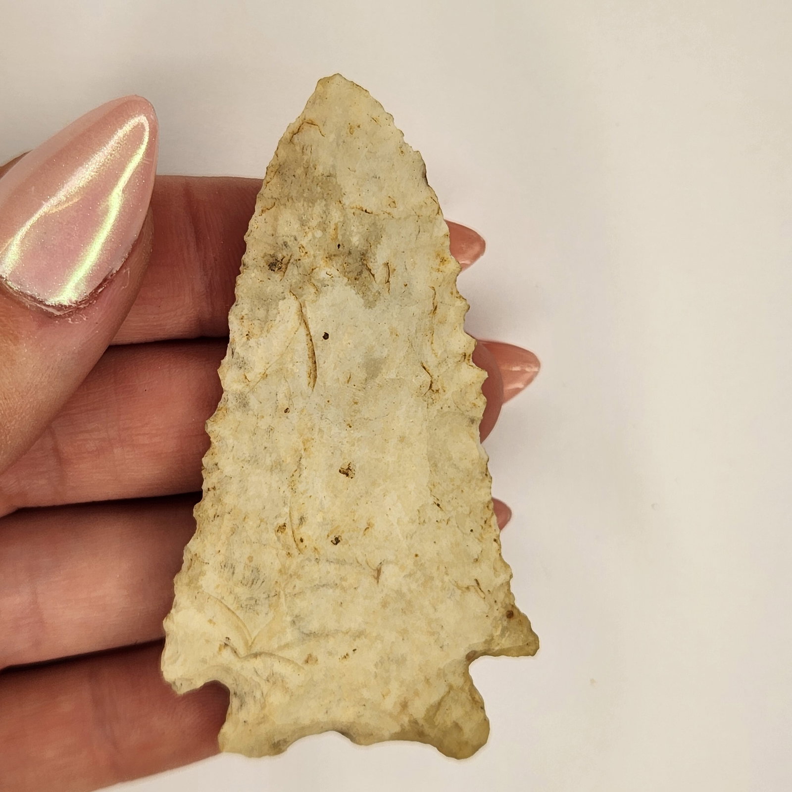 Neubarger: Heavily textured tan point with flared base and short barbs, exhibiting characteristic Neubarger features.reference: native american, indian artifact, arrowhead, paleo, clovis, dalton, beadwork.Dimens