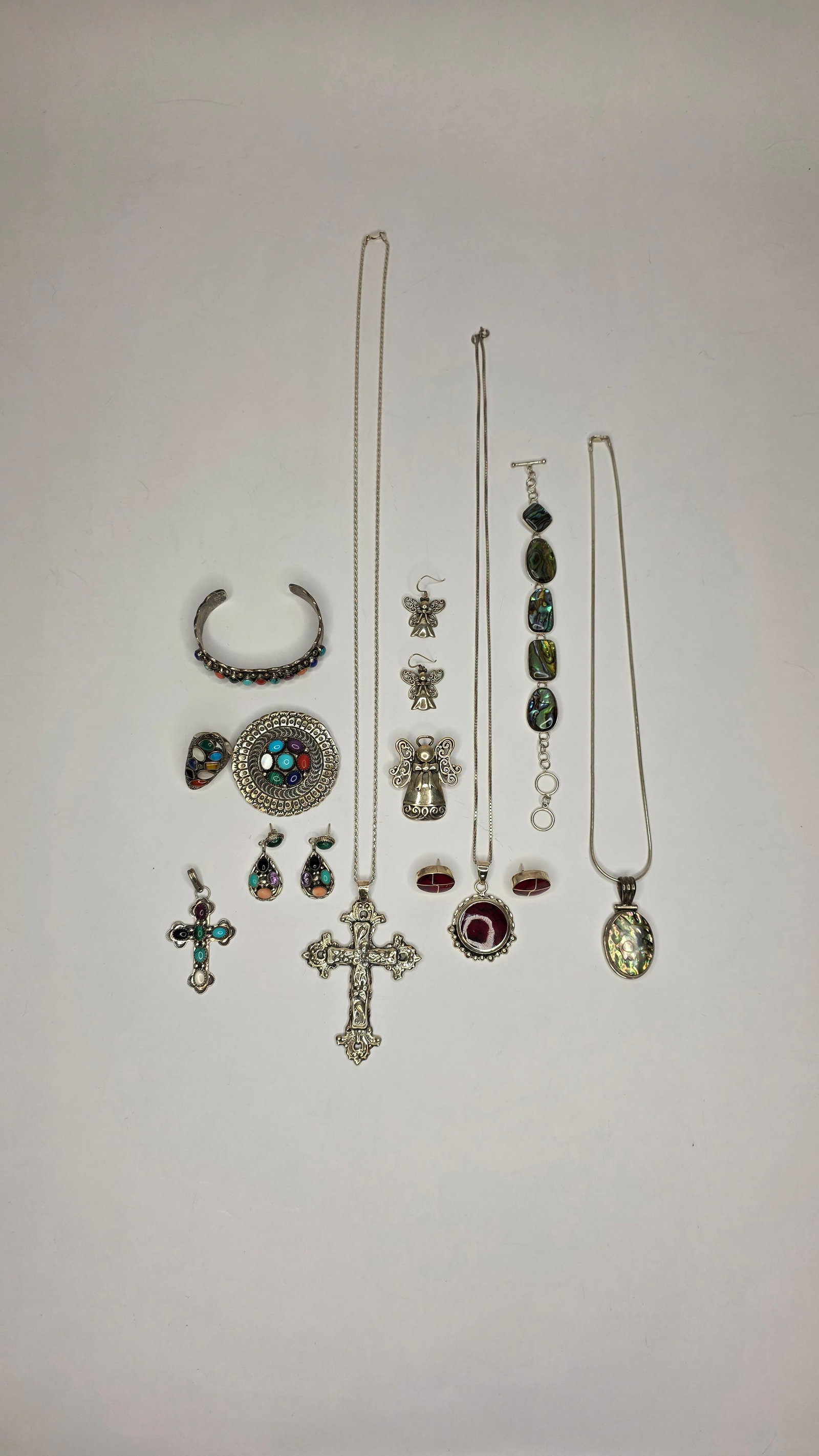 Silver Jewelry #7: Lot of colorful silver jewelry including angel pendants, abalone bracelets, enameled crosses, and a variety of dangle earrings with gemstone and glass accents. Dimensions 6x5x3