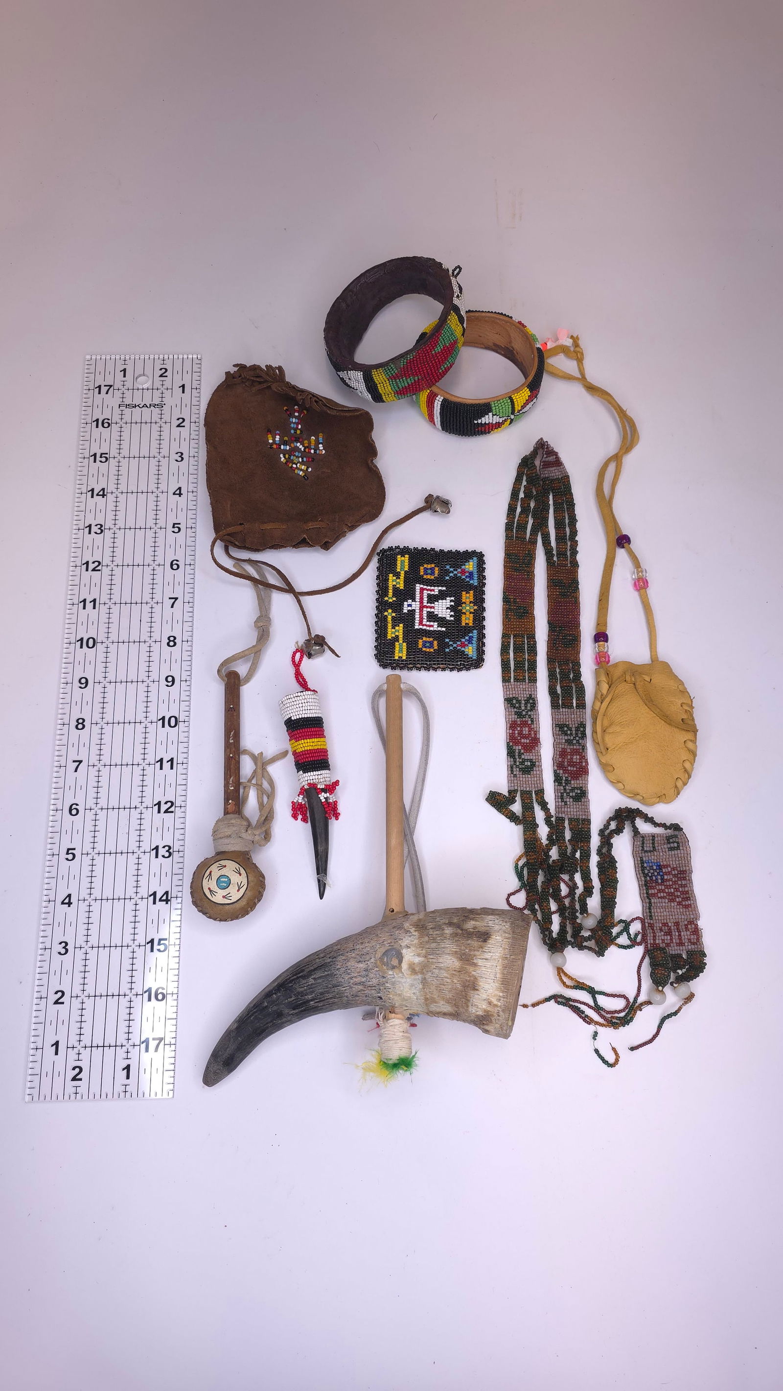 Loit of Misc Native Items #2: Mixed group including two beaded bracelets/bangles, small leather pouches with beadwork, beaded medallion, beaded sheath/straps, small rattle or dance stick. Condition mixed. Reference: native America