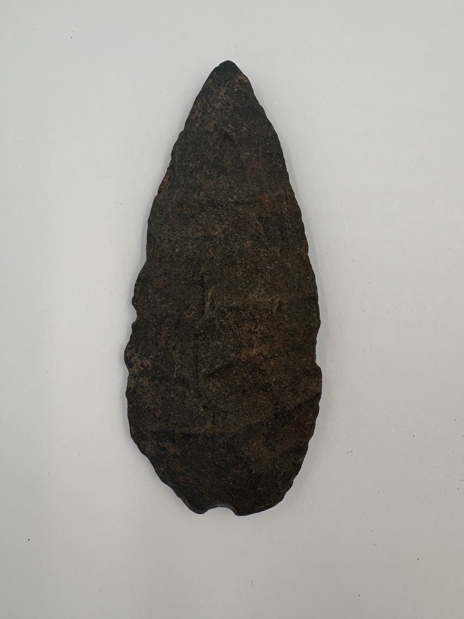 Sugar Quartz Blade - 3 3/4in: Dark brown-black sugar quartz blade measuring 3 3/4 inches with an elongated, leaf-shaped outline and a pointed tip. Bifacial flake scars produce a textured, granular surface and retouched edges run a